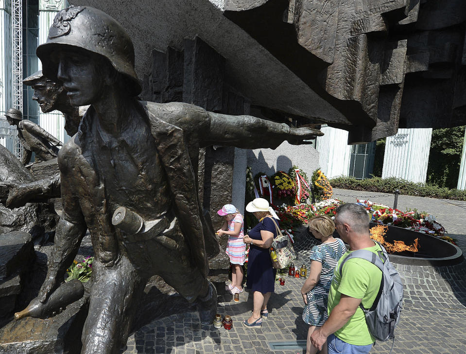 Warsaw residents stop by the monument to the 1944 Warsaw Rising against the occupying Nazis in memory of some 18,000 resistance fighters who fell in the struggle against the German forces and some 180,000 civilians who perished 74 years ago,in Warsaw, Poland, Wednesday, Aug. 1, 2018.(AP Photo/Czarek Sokolowski)