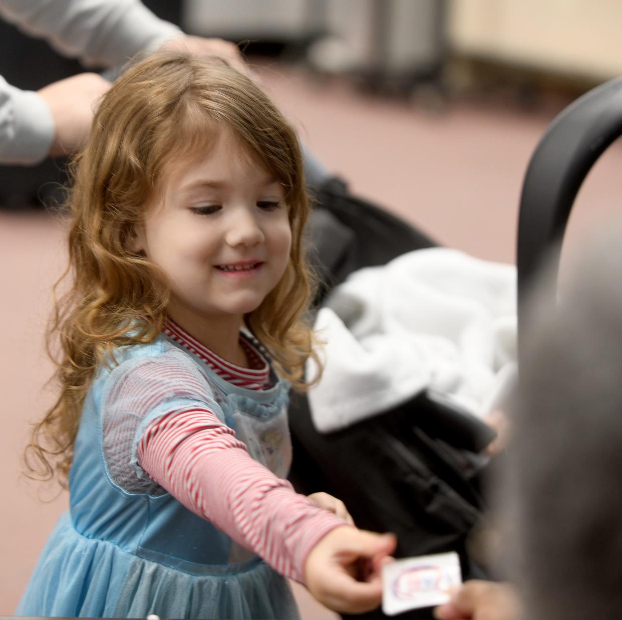 Madison Powers, 4, collects a voting sticker after her mother, Heather Powers of Massillon, cast her vote Tuesday at St. John Lutheran Church in Massillon.
