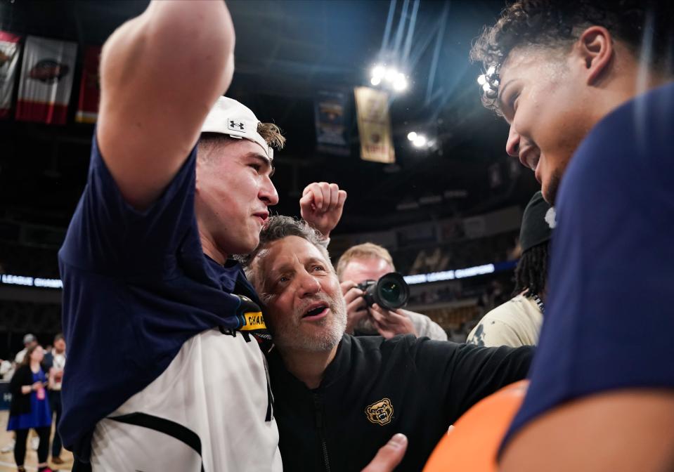 Oakland Golden Grizzlies guard Blake Lampman, left, and head coach Greg Kampe celebrate after defeating the Milwaukee Panthers, 83-76, at Indiana Farmers Coliseum, March 12, 2024 in Indianapolis.