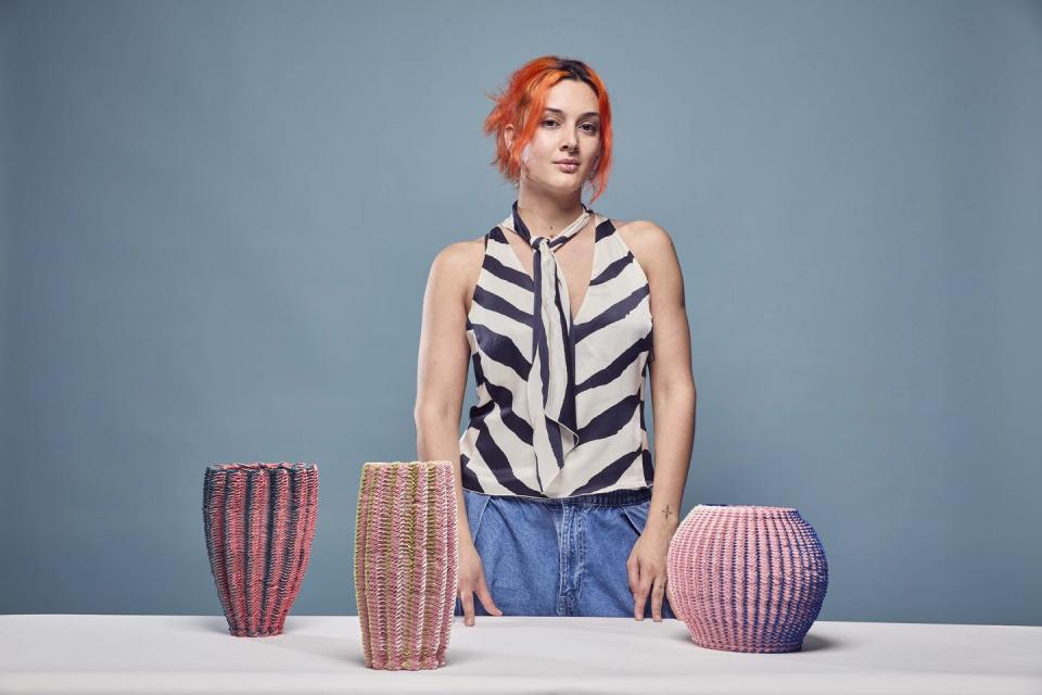 a designer standing behind three vases