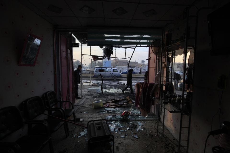 People gather at the site of a car bomb attack in Baghdad's Ghazaliya district, January 15, 2014. Sunni Muslim militants staged coordinated attacks near the western Iraqi city of Falluja on Tuesday, destroying two army tanks and capturing a police station, police said. In Tuesday's deadliest attacks in Baghdad, two car bombs killed nine people and wounded 23 in a crowded street in the mainly Sunni Ghazaliya district, police and medics said. (REUTERS/Ahmed Saad)