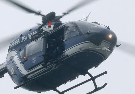 A helicopter with members of the French intervention gendarme forces hover above the scene of a hostage taking at an industrial zone in Dammartin-en-Goele, northeast of Paris January 9, 2015. REUTERS/Christian Hartmann