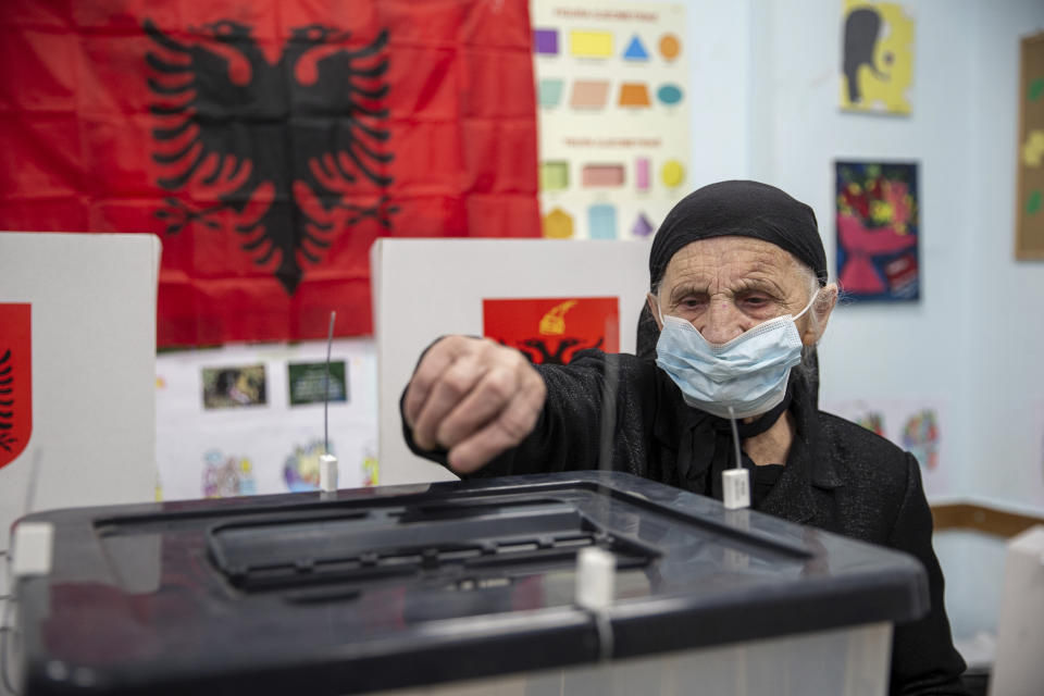 An Albanian woman casts her vote ballot during parliamentary elections in capital Tirana, Albania on Sunday, April 25, 2021. Albanian voters have started casting ballots in parliamentary elections on Sunday amid the virus pandemic and a bitter political rivalry between the country's two largest political parties. (AP Photo/Visar Kryeziu)