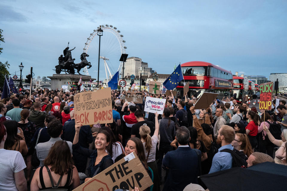 Hundreds of people are seen protesting against Boris Johnson outside the houses of parliament on Westminster bridge