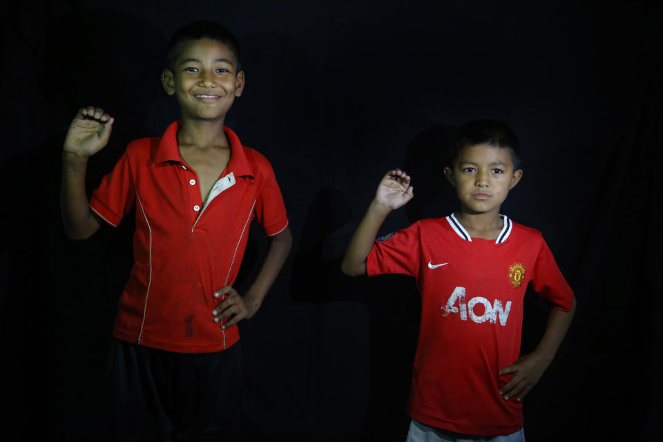 In this Sept. 26, 2018, photo, 10-year-old Salik Suwal, right, and 11-year-old Pujan Machamasi pose for a photograph without their masks of god Kawancha in Kathmandu, Nepal. For centuries, Nepal has celebrated the Indra Jatra festival of masked dancers, which officially begins the month-long festivities in the Hindu-dominated Himalyan nation. The dancers, who come from a variety of backgrounds, pull off this performance every year despite minimal financial support from the government and other sources, they say. (AP Photo/Niranjan Shrestha)