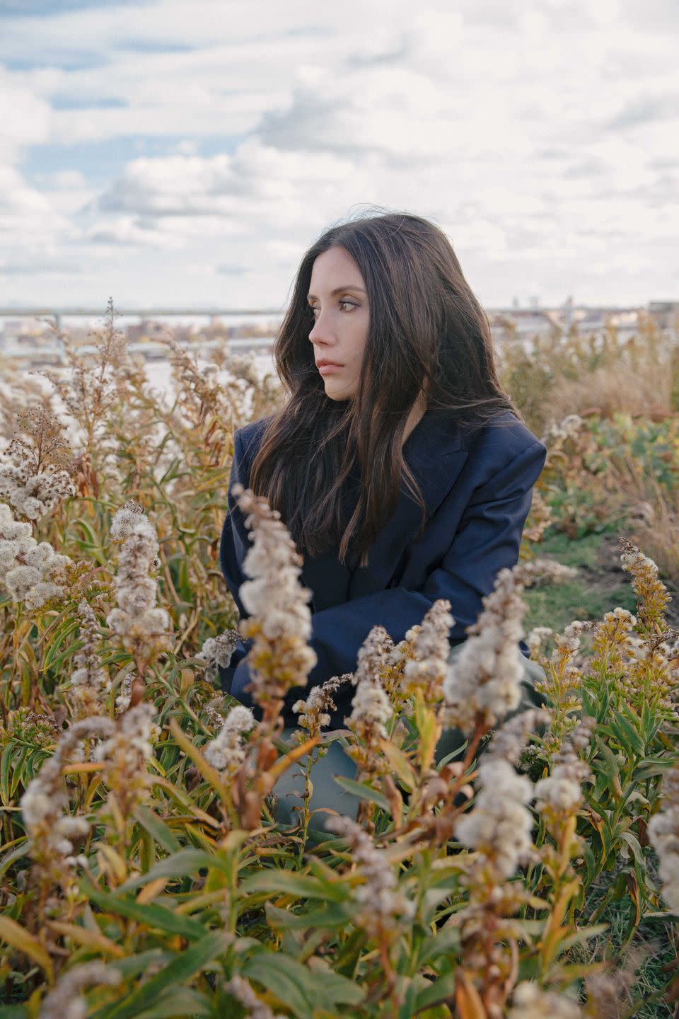 emma handler stands amid flowers on a roof