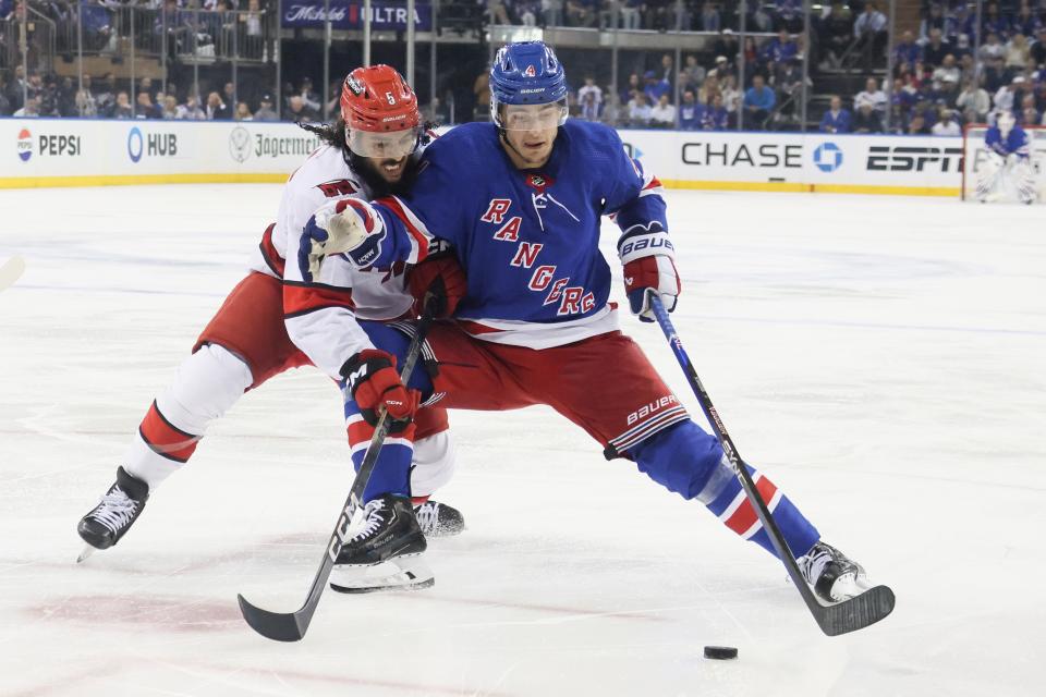 NEW YORK, NEW YORK - MAY 07: Jalen Chatfield #5 of the Carolina Hurricanes and Braden Schneider #4 of the New York Rangers fight for the puck during the second period in Game Two of the Second Round of the 2024 Stanley Cup Playoffs at Madison Square Garden on May 07, 2024 in New York City.