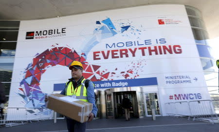 A worker carries a box next to the main entrance of the Mobile World Congress in Barcelona, Spain February 20, 2016. REUTERS/Albert Gea