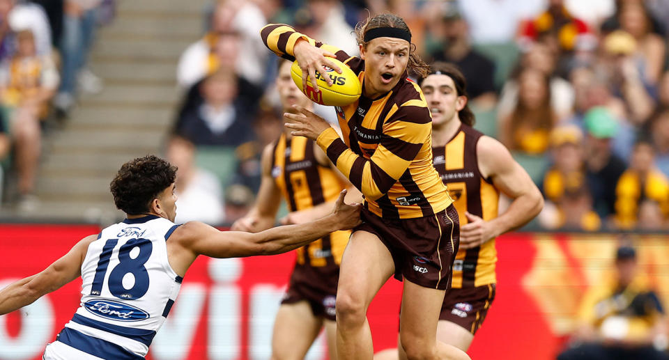 Hawthorn's Jack Ginnivan tries to evade a Geelong tackle in the Easter Monday AFL blockbuster at the MCG. Pic: Getty