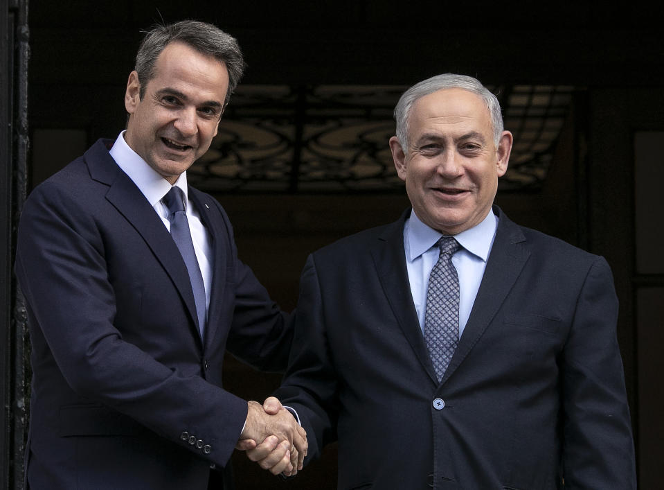 Greece's Prime Minister Kyriakos Mitsotakis, left, welcomes his Israeli counterpart Benjamin Netanyahu in Athens, Thursday, Jan. 2, 2020. The leaders of Greece, Israel and Cyprus will meet in Athens Thursday to sign a deal aiming to build a key undersea pipeline, named EastMed, designed to carry gas from new rich offshore deposits in the southeastern Mediterranean to continental Europe.(AP Photo/Yorgos Karahalis)