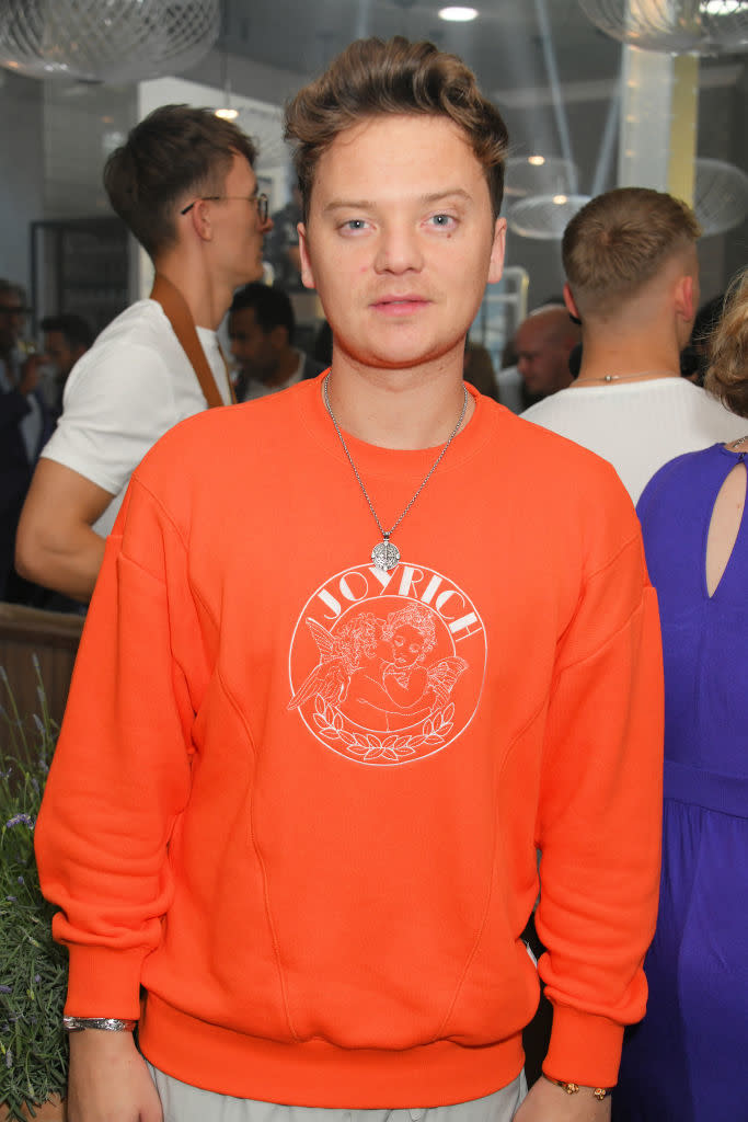Conor in sweatshirt with "JOYRICH" logo at an event