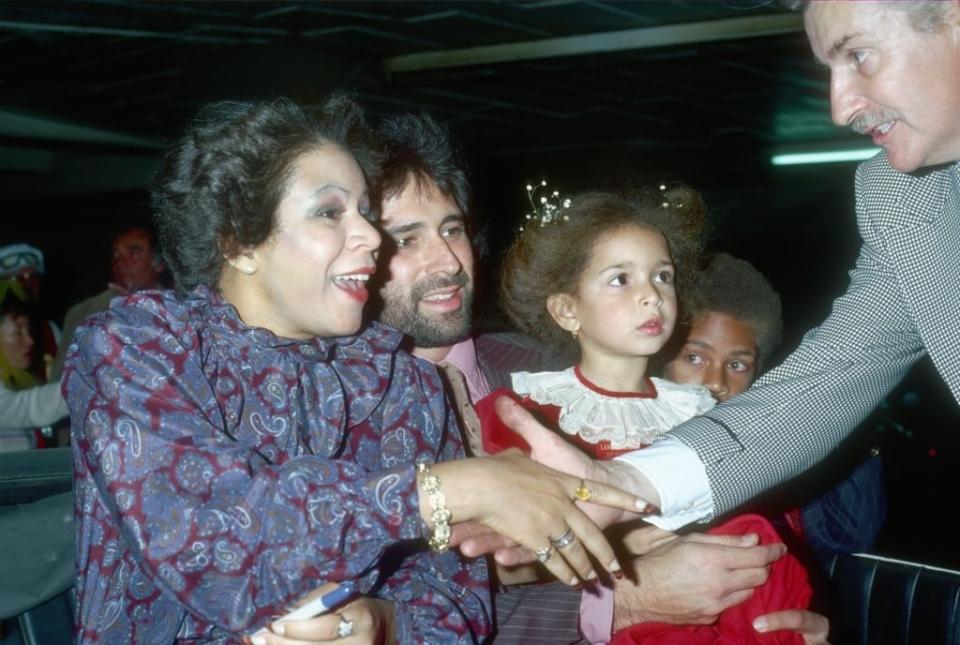 Minnie Riperton shakes a fan's hand while Richard Rudolph holds Maya and Marc Rudolph is in the background