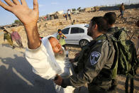 <p>Palestinian shed owner Sulaiman Hathaleen (L) scuffles with Israeli border police after Israeli troops demolished his shed in the West Bank village of Um Alkhair, south of Hebron, Aug. 24, 2016. The Israeli army claims that the Palestinians did not have the needed Israeli permits to build in this area of the West Bank. (Photo: ABED AL HASHLAMOUN/EPA) </p>