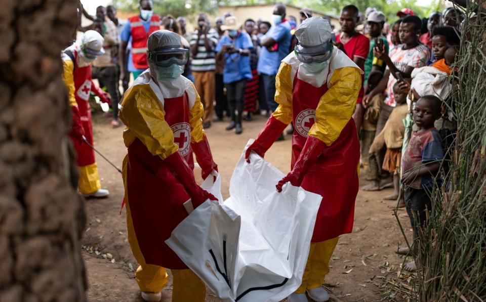 Red Cross workers carry a body bag containing a 3-year-old boy suspected of dying from Ebola - Luke Dray/Getty Images