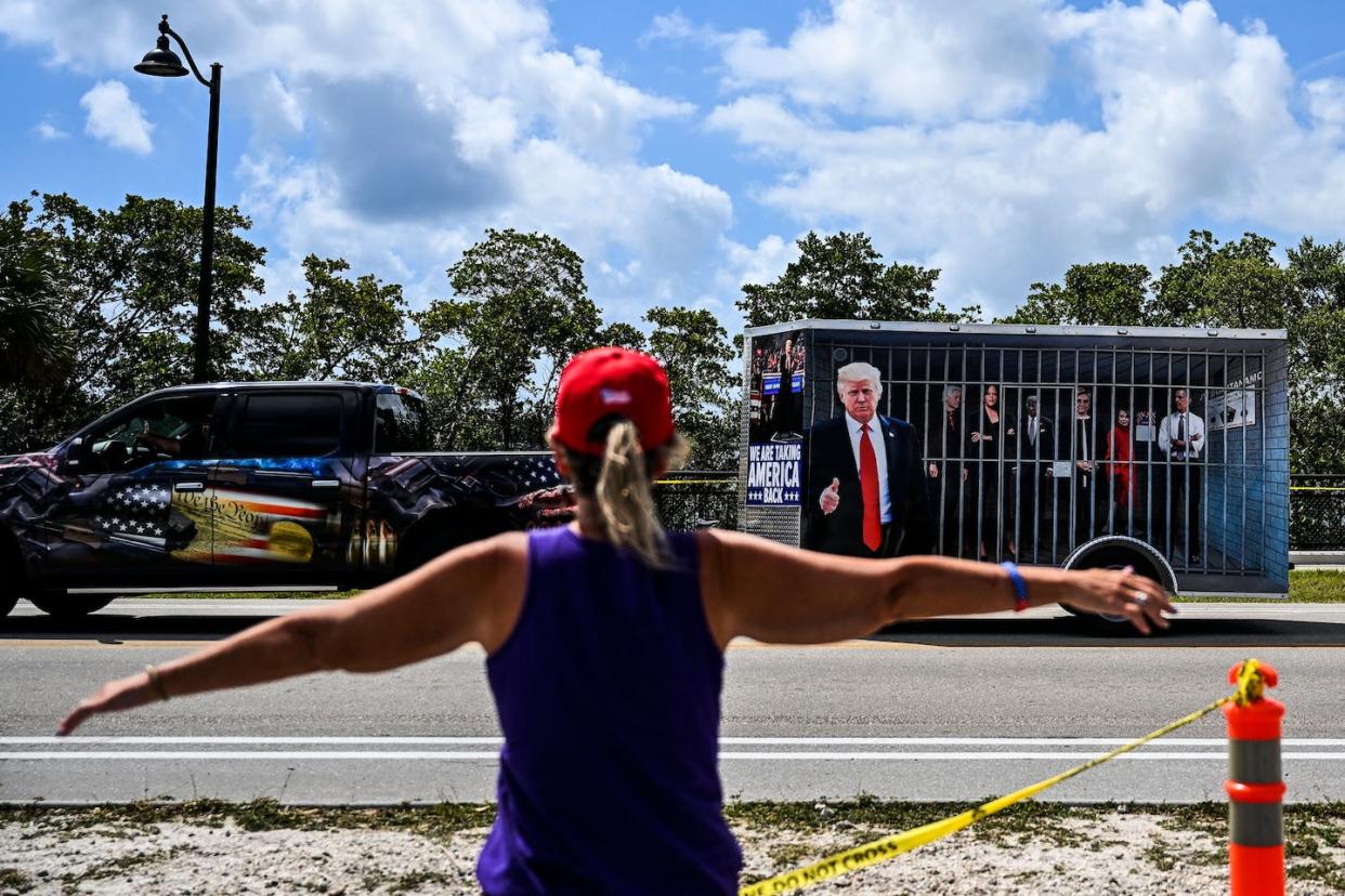 A supporter of former President Donald Trump protests the indictment announcement near Mar-a-Lago, Fla., on March 31, 2023. <a href="https://media.gettyimages.com/id/1250111292/photo/us-politics-trump-indictment.jpg?s=1024x1024&w=gi&k=20&c=zyr9SAhaiWdv6p8cj0WK5MrRYjw8yfuBis-jlqjYveE=" rel="nofollow noopener" target="_blank" data-ylk="slk:Chandan Khan/AFP via Getty Images;elm:context_link;itc:0;sec:content-canvas" class="link ">Chandan Khan/AFP via Getty Images</a>