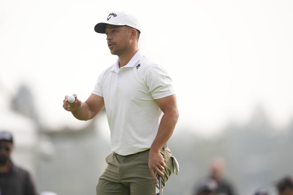 Xander Schauffele waves to the gallery as he finishes his round on the 18th green during the third round of the Genesis Invitational golf tournament at Riviera Country Club, Saturday, Feb. 17, 2024, in the Pacific Palisades area of Los Angeles. (AP Photo/Ryan Sun)