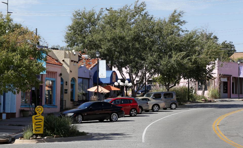 This Oct. 9, 2013 photo shows shops in the colorful Paseo Arts District are pictured in Oklahoma City. The two-block art district is lined with stucco buildings showcasing their Spanish influence. (AP Photo/Sue Ogrocki)