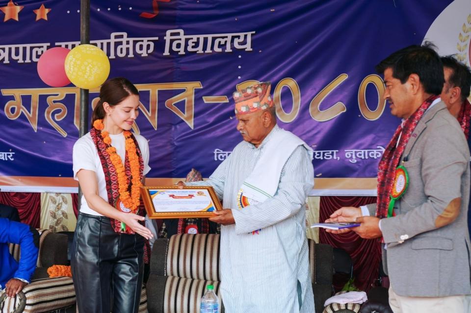 尼泊爾前總統（中）頒發感謝狀給安妮（左）。伊林娛樂提供