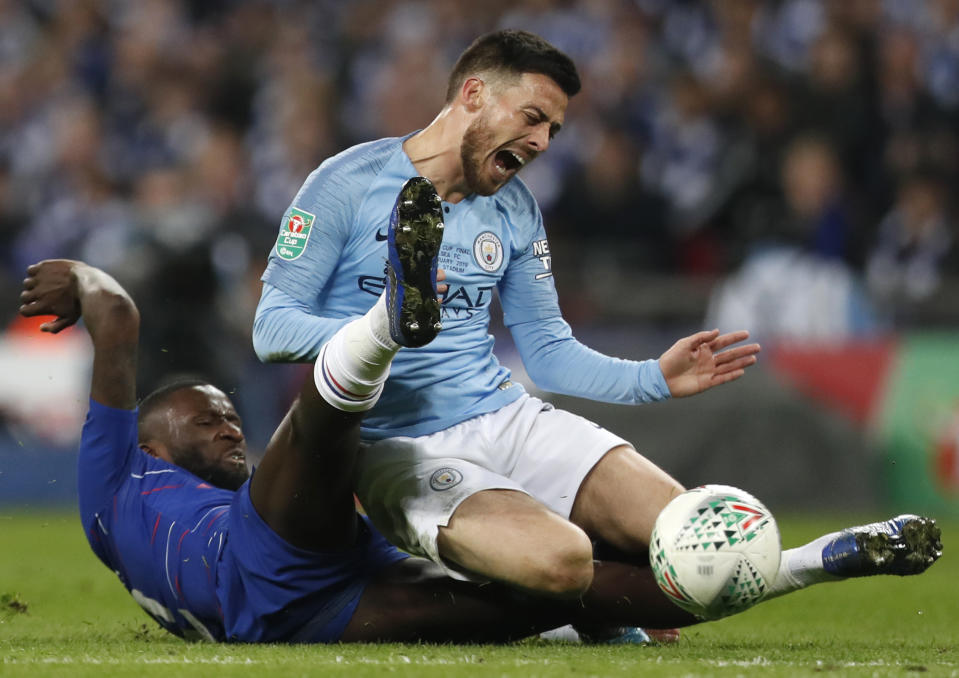Chelsea's Antonio Rudiger, left, tackles Manchester City's David Silva, right, during the English League Cup final soccer match between Chelsea and Manchester City at Wembley stadium in London, England, Sunday, Feb. 24, 2019. (AP Photo/Alastair Grant)