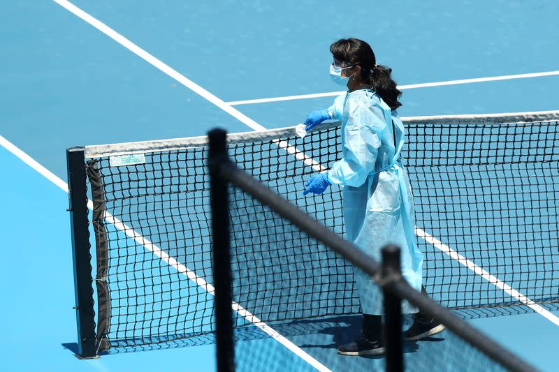 FILE PHOTO: A staff member wearing PPE works to clean surfaces at Melbourne Park in Melbourne