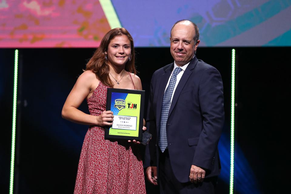 Olivia Moreno of Bowie accepts the Girls Athlete of the Year honors from American-Statesman sports editor Jason Jarrett at the 2022 Austin High School Sports Awards ceremony Monday at the Long Center.