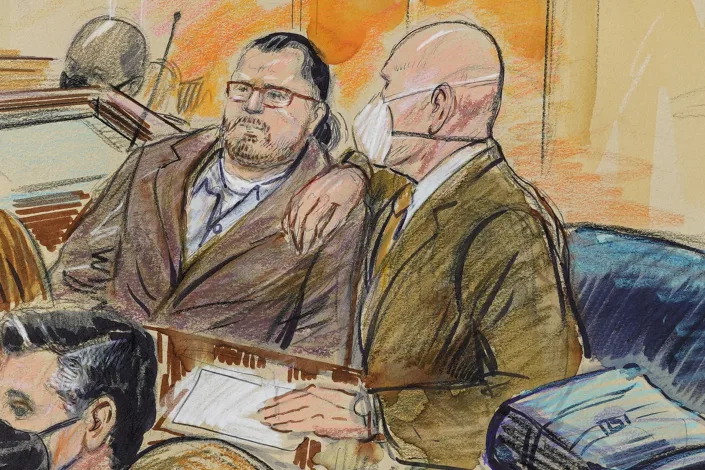 This artist sketch depicts Guy Wesley Reffitt, joined by his lawyer William Welch, right, in Federal Court, in Washington, Monday, Feb. 28, 2022. Reffitt, a Texas man charged with storming the U.S. Capitol with a holstered handgun on his waist, is the first Jan. 6 defendant to go on trial. (Dana Verkouteren via AP)