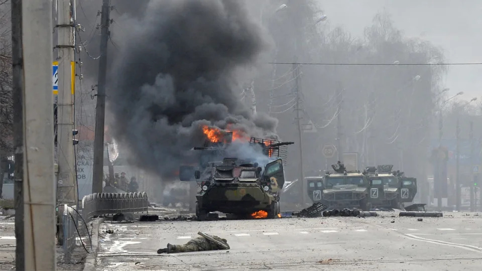 A Russian Armoured personnel carrier (APC) burns next to an unidentified soldier's body during a fight with the Ukrainian armed forces in Kharkiv. <span class="copyright">Photo by SERGEY BOBOK/AFP via Getty Images</span>