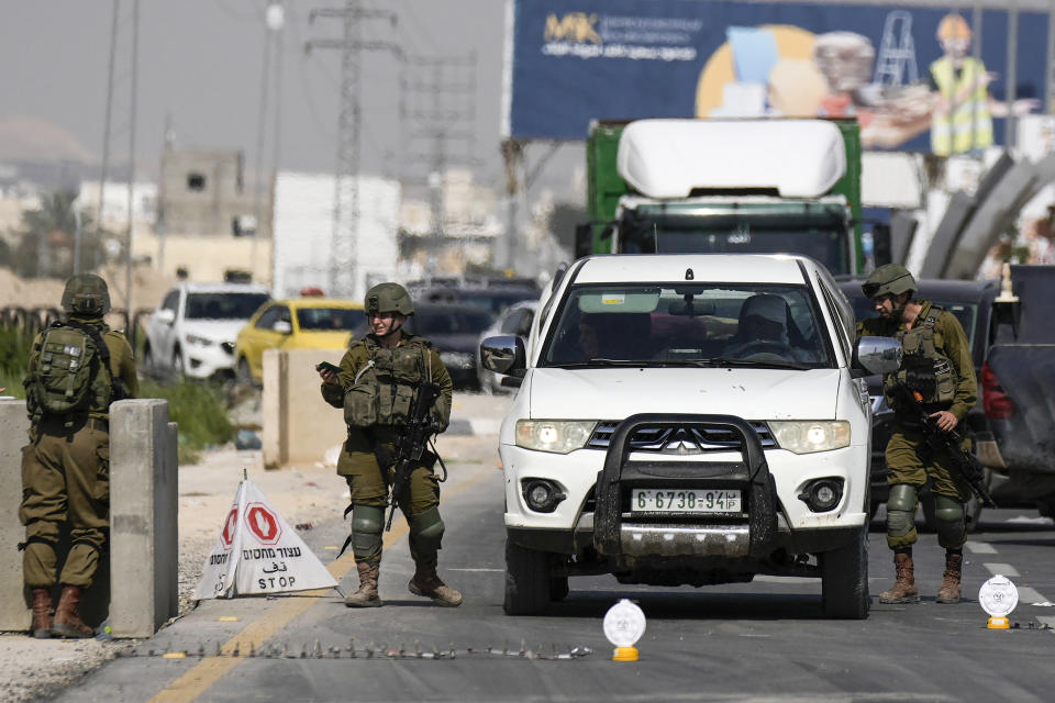 Israeli soldiers search a Palestinian's car after Monday's shooting attack took place on a main highway near the Dead Sea and the West Bank Palestinian town of Jericho, Tuesday, Feb. 28, 2023. Israeli authorities says the motorist killed by a suspected Palestinian gunman in the occupied West Bank held citizenship in both the United States and Israel. (AP Photo/Majdi Mohammed)