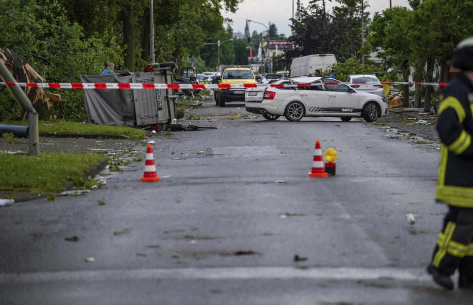 Damaged cars stand on a road during a storm in Paderborn, Germany, Friday, May 20, 2022. A tornado swept through the western German city of Paderborn on Friday, injuring at least 30 people as it blew away roofs, toppled trees and sent debris flying for miles, authorities said. (Lino Mirgeler/dpa via AP)