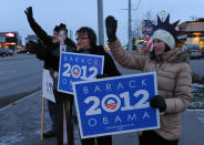 John Hoffman, with a card board President Obama, Cindy Emery and Sarah Robinson wave signs in support of the President early on Election Day at the corner of the Seward Highway and Benson Boulevard in Anchorage on Tuesday, Nov. 6, 2012. (AP Photo/Anchorage Daily News, Bob Hallinen)