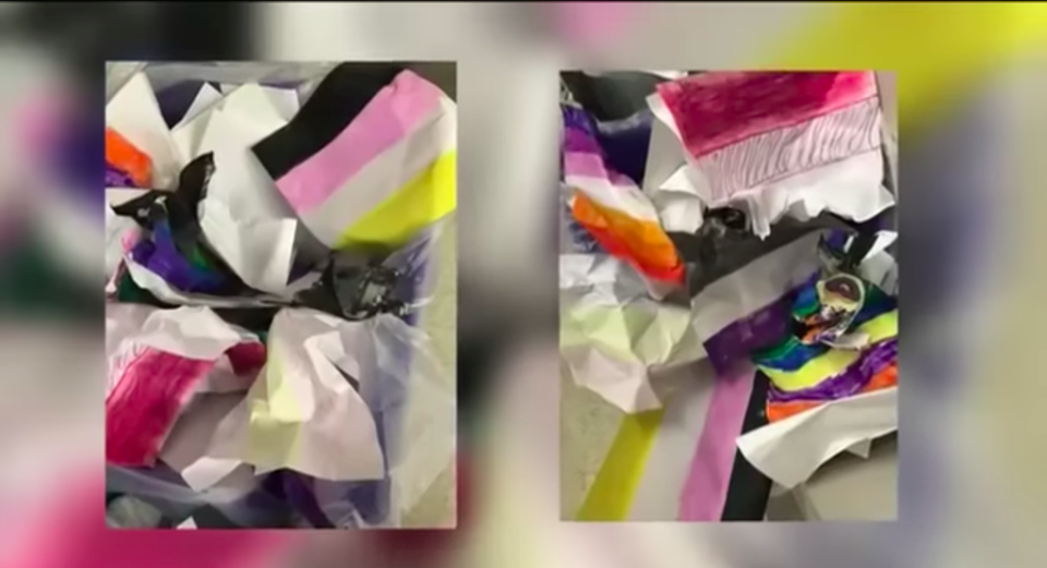 The crumpled up flags from Casey Scott’s art class are seen in a recycling bin after she was asked by school administrators to remove the illustrations from her wall. (WWBH News/screenshot)