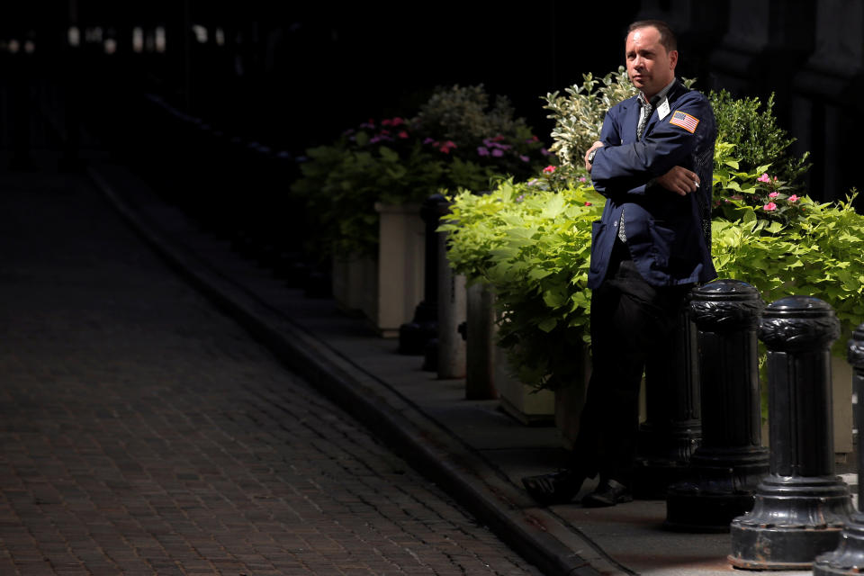 A trader stands outside the New York Stock Exchange.