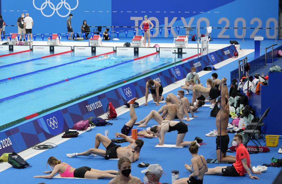 FILE - In this July 22, 2021, file photo, Germany's team exercises during a swimming training session at the Tokyo Aquatics Centre at the 2020 Summer Olympics in Tokyo. With hundreds of swimmers scrambling to get their warmup done at the same time, multiple athletes in each lane, everyone diving over one another and some competitors using snorkels, kickboards and other paraphernalia, warmup is organized chaos. (AP Photo/Martin Meissner, File)