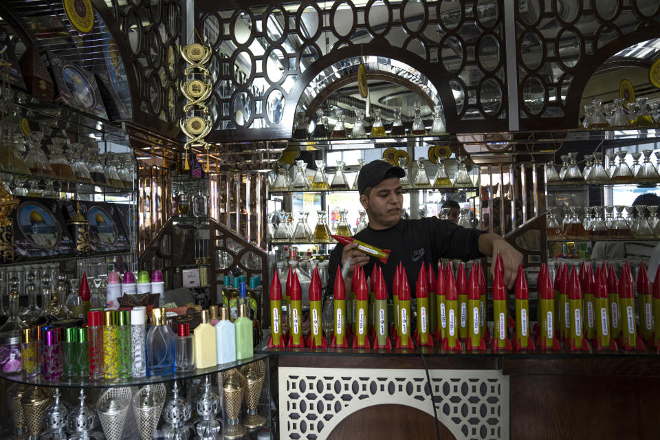 Belal Abu Saraya arranges perfume containers representing rockets used against Israel in a perfume store against Israel in past conflicts at his shop in Gaza City on Thursday, Oct. 5, 2023. AP Photo/Fatima Shbair)