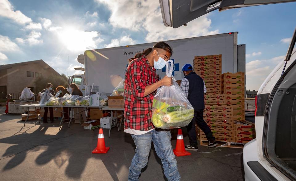 Elijah Ramirez and other volunteers distribute food Wednesday, November 10, 2021 from FoodLink at Mt. Zion Church in Goshen. About 150 families were served during this event.