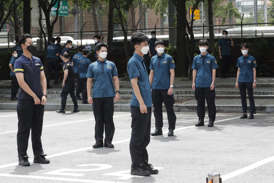 Police officers wait for their COVID-19 testing while maintaining social distancing at the Seoul Metropolitan Police Agency in Seoul, South Korea, Wednesday, Aug. 19, 2020. (AP Photo/Ahn Young-joon)