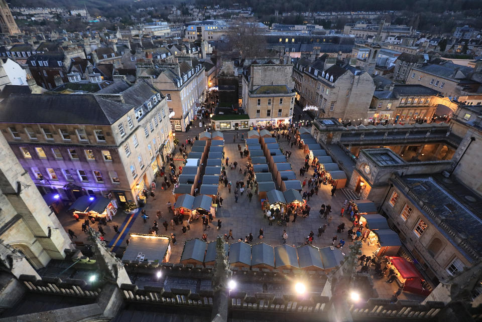 BATH, ENGLAND - DECEMBER 08:  Christmas shoppers browse stalls at the traditional Christmas market close to the historic Roman Baths and Bath Abbey on December 8, 2015 in Bath, England. Originating in Germany, Christmas markets have become increasingly popular in British cities as a way of boosting festive sales and visitor numbers.  (Photo by Matt Cardy/Getty Images)