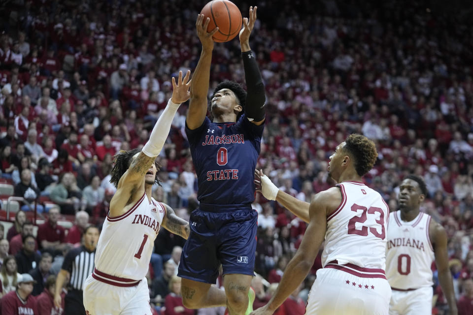 Jackson State guard Gabe Watson (0) puts up a shot against Indiana guard Jalen Hood-Schifino (1) and forward Trayce Jackson-Davis (23) during the first half of an NCAA college basketball game, Friday, Nov. 25, 2022, in Bloomington, Ind. (AP Photo/Darron Cummings)