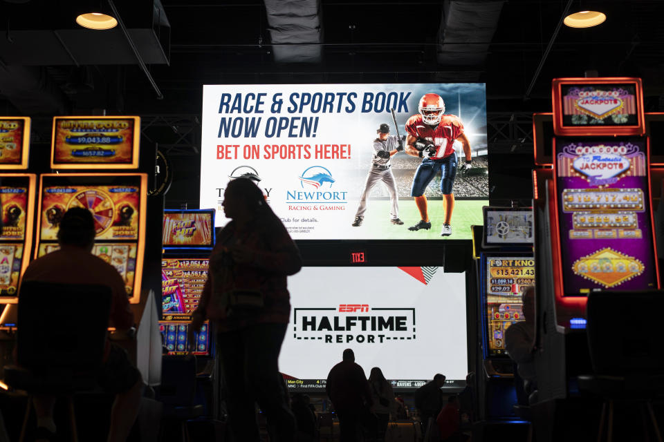 A huge TV screen at the entrance of Churchill's Bourbon & Brew Bar & Grille, flanked by electronic gaming machines, promotes sports betting at Turfway Park Racing & Gaming, Friday, Dec. 22, 2023, in Florence, Ky. Sports betting has spread rapidly across U.S. states in the past five years. But the odds for further expansion may be fading as state legislatures prepare to return to work in 2024. (AP Photo/Carolyn Kaster)