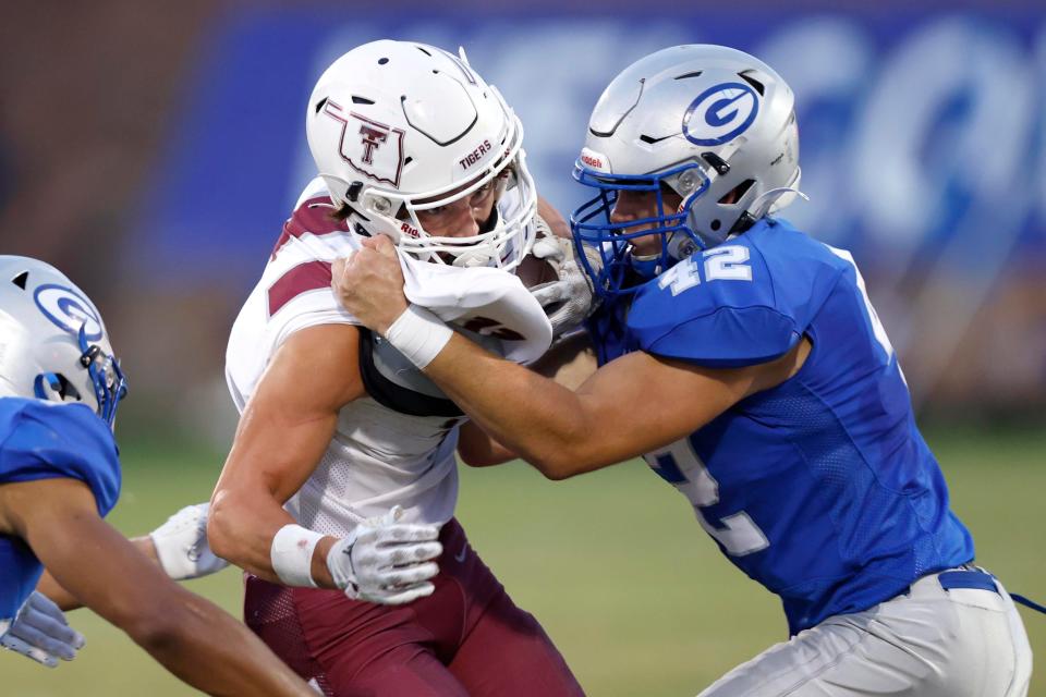 Guthrie's Eli Moroney brings down Tuttle's Brady McAdoo during a high school football game between Guthrie and Tuttle in Guthrie, Okla., Friday, Sept. 15, 2023