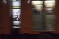 A subway going past frames an advertisement showing an image of Mexican former President Carlos Salinas, obscuring his eyes with a red bar, and calling for citizens to participate in a referendum on whether ex-presidents should be tried for their alleged crimes during their time in office, in Mexico City, Saturday, July 31, 2021. The yes-or-no referendum on Sunday is going to cost Mexico about $25 million, and the vote is being held in the middle of a third wave of the coronavirus pandemic. (AP Photo/Christian Palma)