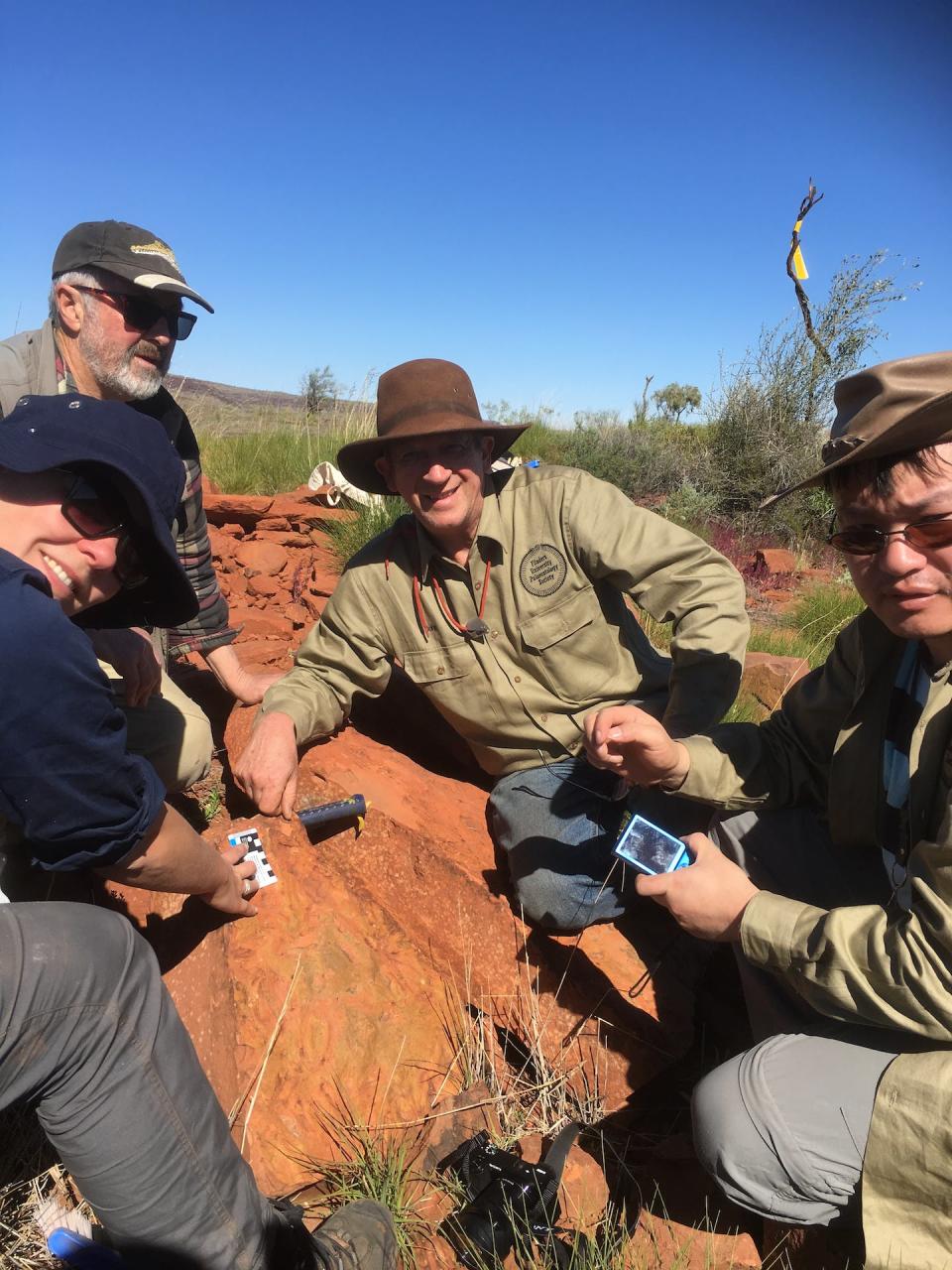 The moment of discovery when we found a complete fossil of <em>Harajicadectes</em> in 2016. Flinders University palaeontologists John Long (centre), Brian Choo (right) and Alice Clement (left) with ANU palaeontologist Gavin Young (top left). Author provided