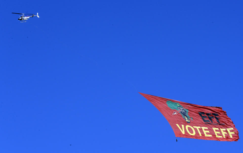 A helicopter pulls an Economic Freedom Fighters (EFF) party's banner, over Orlando Stadium in Soweto, South Africa, Sunday, May 5, 2019. Campaign rallies for South Africa’s upcoming election have reached a climax Sunday with mass rallies by the ruling party and one of its most potent challengers. (AP Photo/Themba Hadebe)