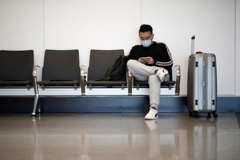 Travellers wearing masks arrive on a direct flight from China, in Paris