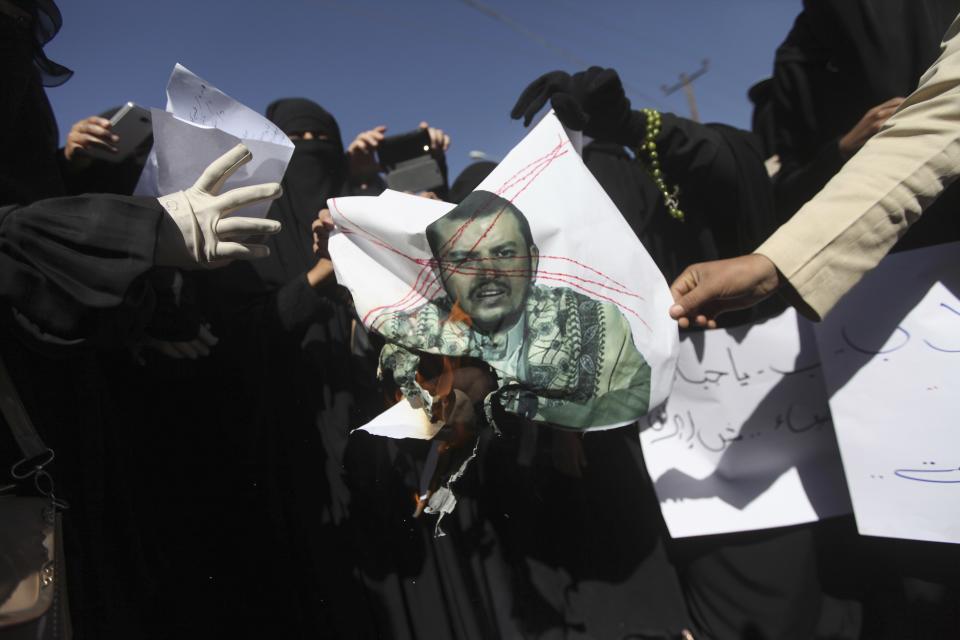 Anti-Houthi protesters burn an image of the leader of Yemen's Houthi movement, Abdel Malek al-Houthi, during a rally in Sanaa