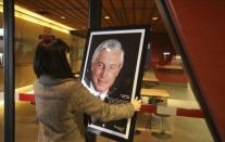 A woman places a photo of Jean Beliveau inside the arena named after him in Longueuil December 3, 2014. REUTERS/Christinne Muschi