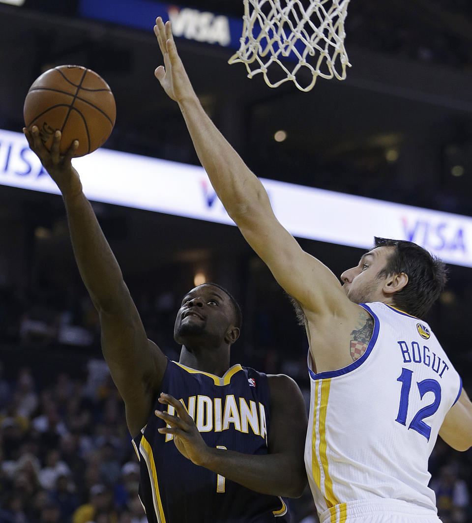 Indiana Pacers' Lance Stephenson, left, lays up a shot against Golden State Warriors' Andrew Bogut (12) during the first half of an NBA basketball game, Monday, Jan. 20, 2014, in Oakland, Calif. (AP Photo/Ben Margot)