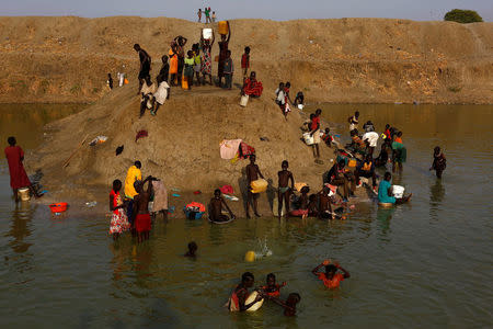 Internally displaced people wash and collect water in a reservoir in the United Nations Mission in South Sudan (UNMISS) Protection of Civilian site (CoP), near Bentiu, northern South Sudan, February 6, 2017. REUTERS/Siegfried Modola