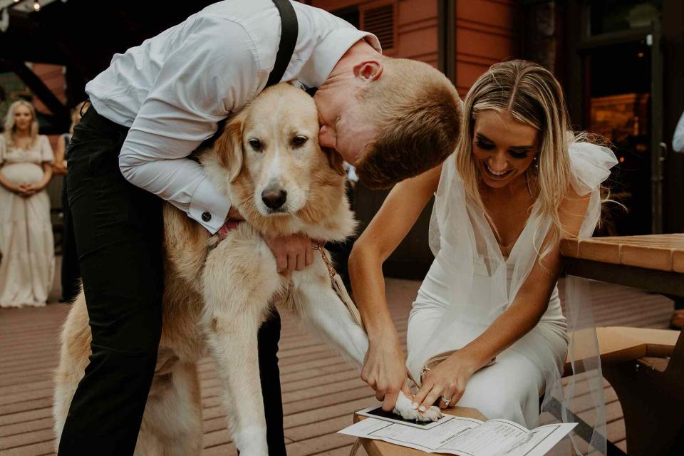 <p>Felicia Renae Photography</p> Kristy and Eric have their dog, Cece, sign their marriage license with a paw print 