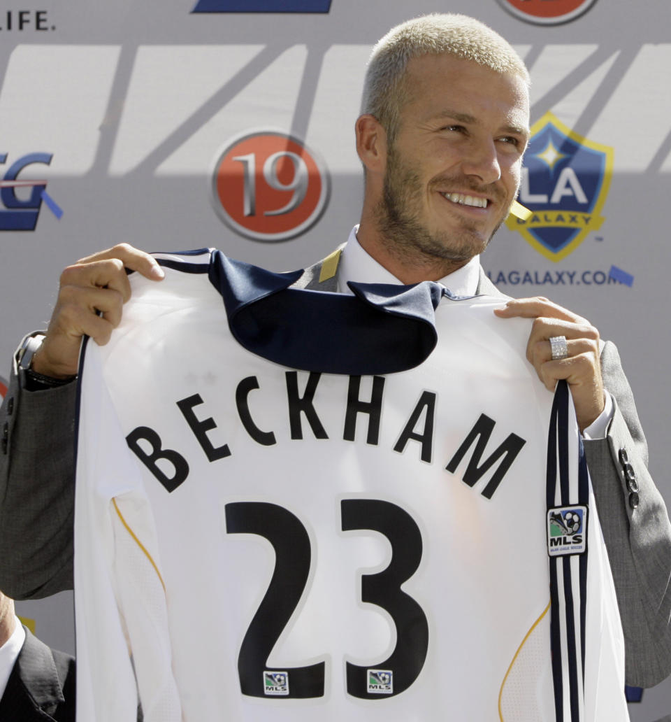 FILE - In this July 13, 2007, file photo, England soccer player David Beckham holds up his new jersey as he is introduced as the newest member of the Los Angeles Galaxy soccer team in Carson, Calif. The 38-year-old midfielder, who recently won a league title in a fourth country with Paris Saint-Germain, said Thursday, May 16, 2013, he will retire after the season.  (AP Photo/Nick Ut, File)